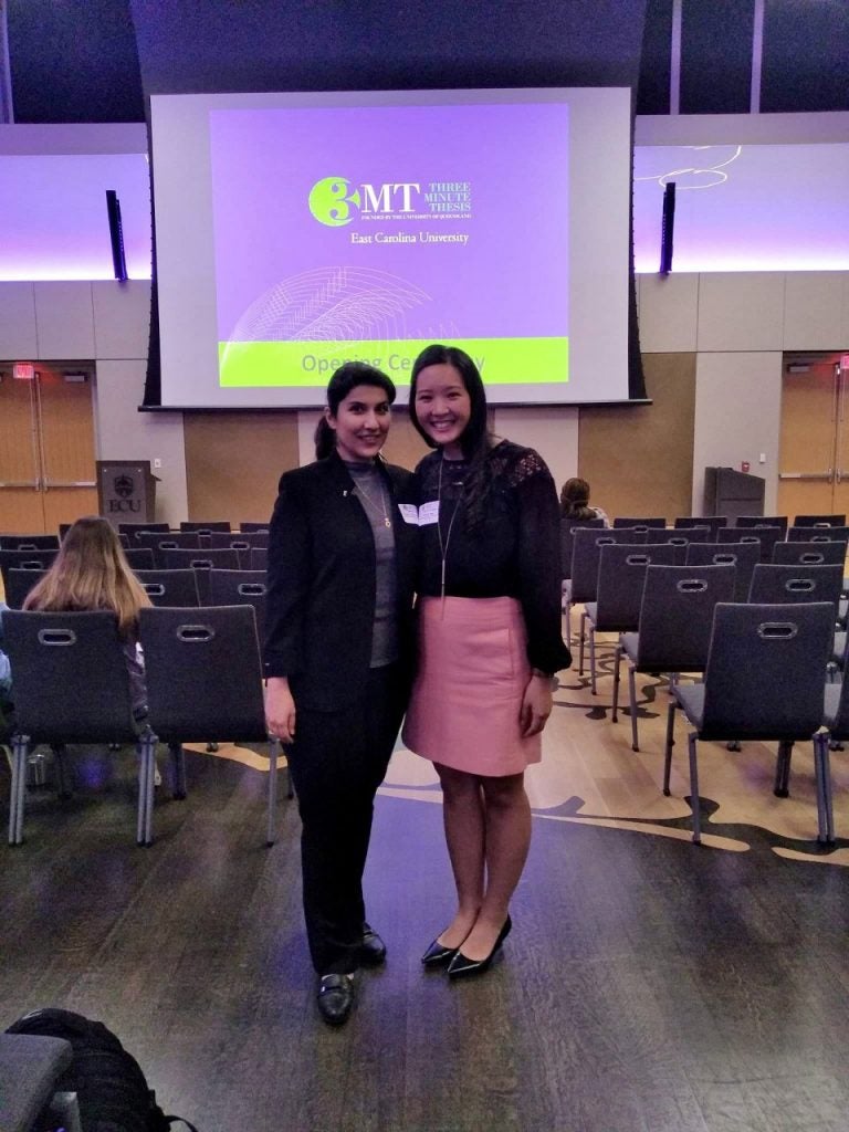 Two female students at the Three Minute Thesis opening ceremony.